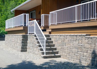 Symmetrical Allan block steps with side railing.